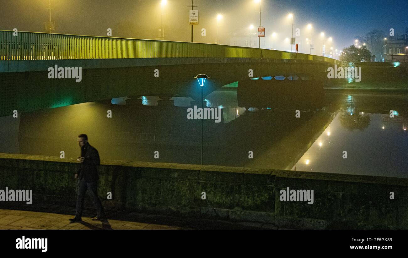 Night fog over Debnicki Bridge over Vistula river, Krakow, Poland, with the perspective of illuminated street lamps Stock Photo