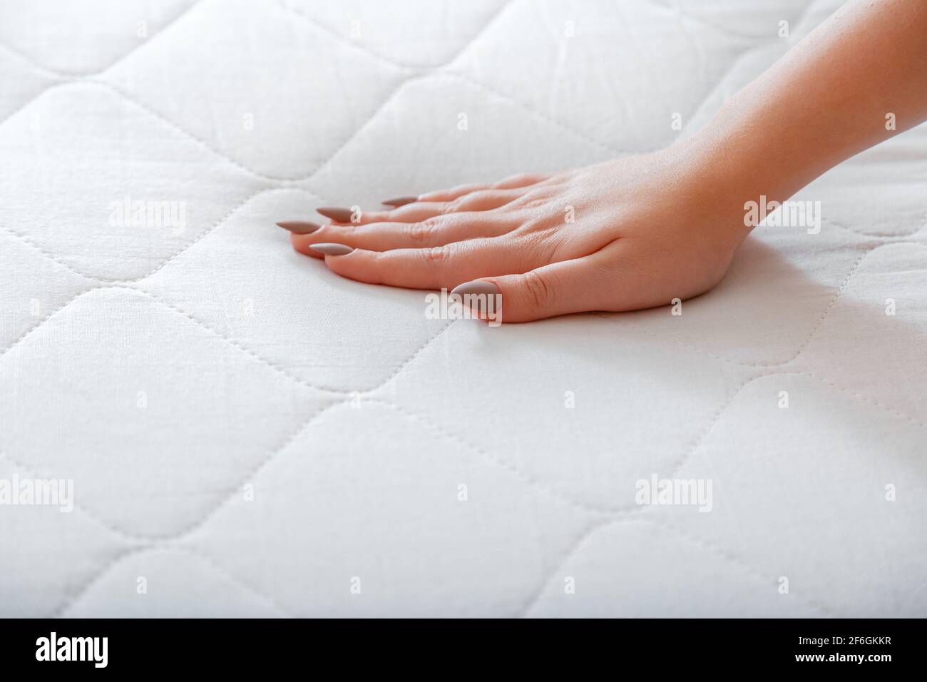 Female hand Pressing Testing mattress to Check softness. Choice