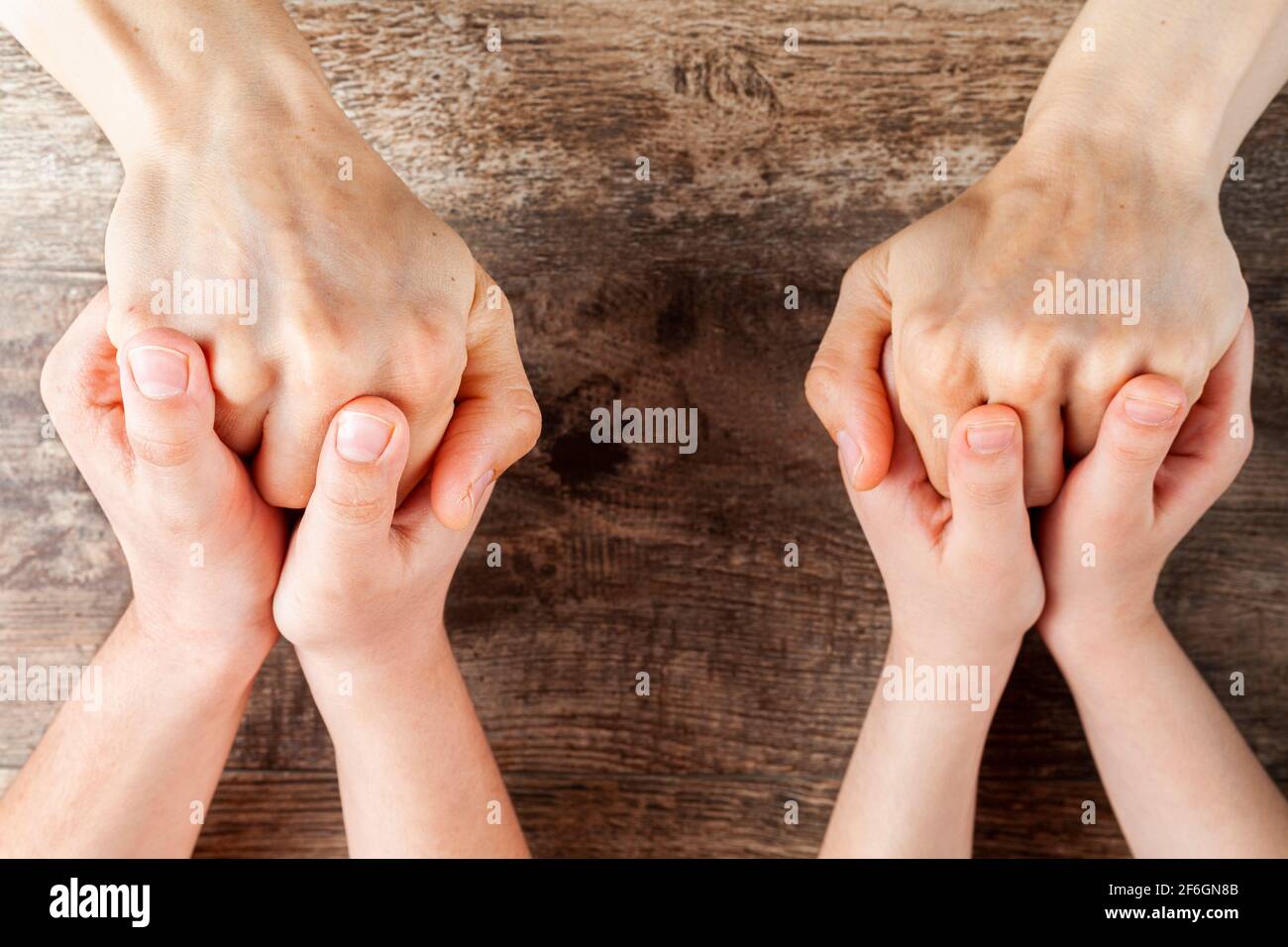 Abstract concept image showing two kids tightly holding hands of a woman. Single mom with two kids, family difficulties, staying strong, caring family Stock Photo