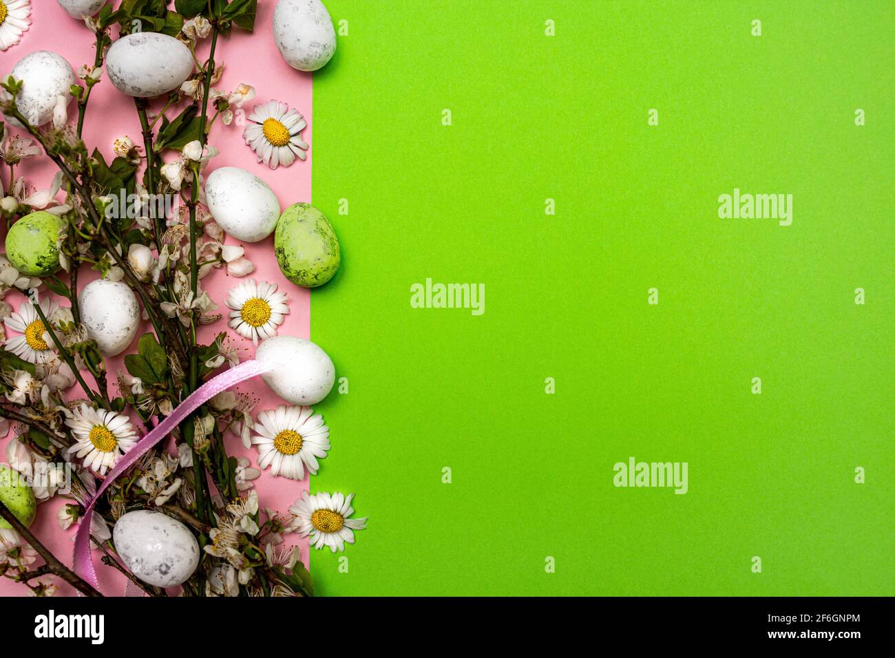 Colorful Easter eggs and flowers on pink and green background. Spring ...