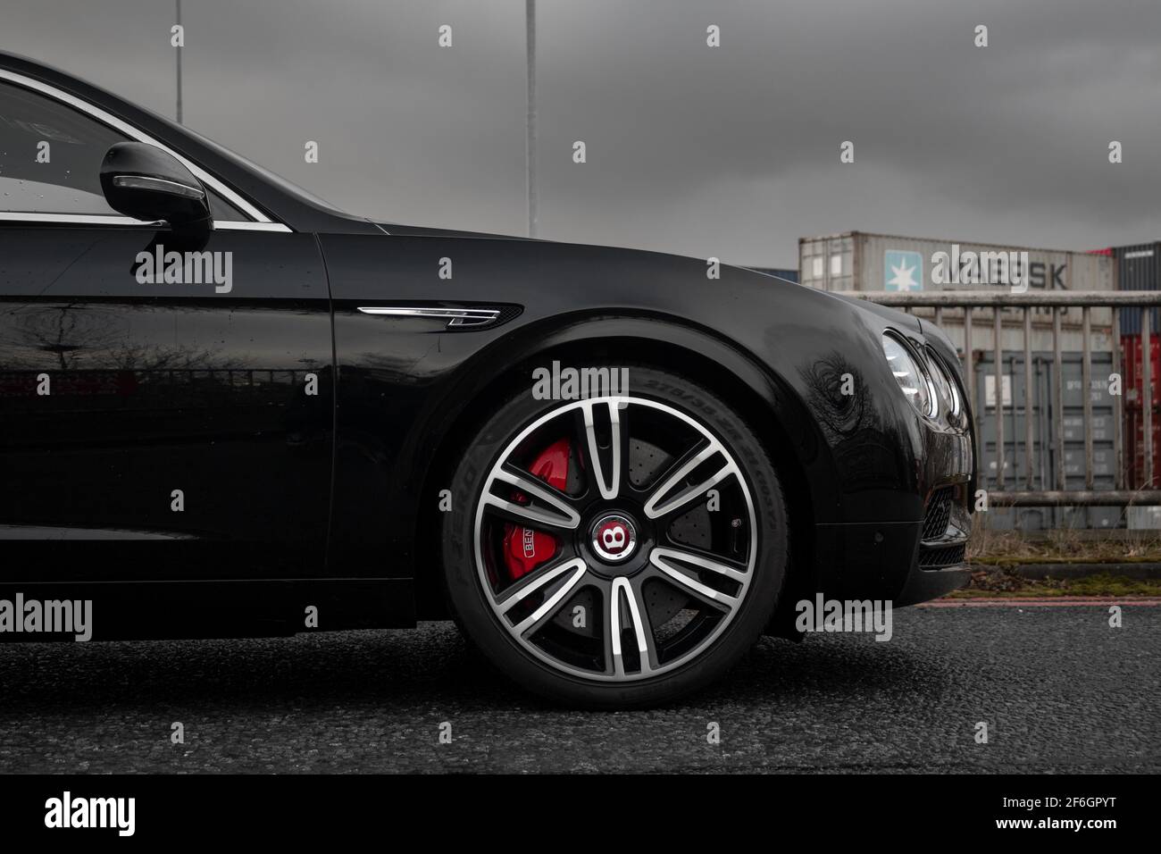 The Front Of A Gloss Black 2016 Bentley Continental Flying Spur With Black And SIlver Wheels Red Brake Callipers With Bentley Logo Stock Photo