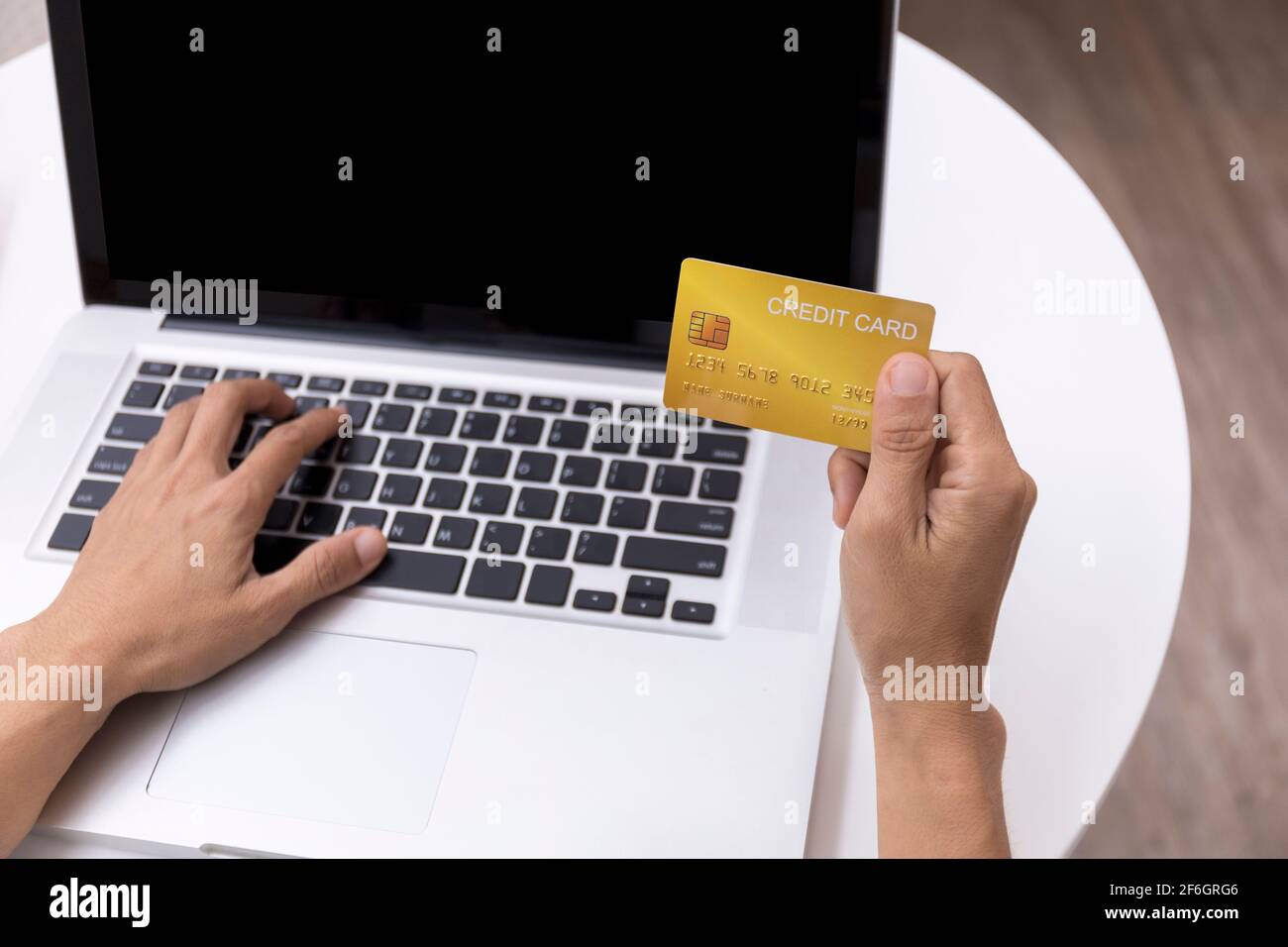 Young woman holding credit card and using laptop computer. Women working at home. Online shopping, e-commerce, internet banking, spending money, worki Stock Photo