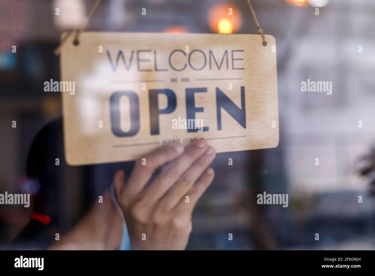 Hand of asian owner retail ,coffee shop woman turning sign board to open. Protection to pandemic of coronavirus. Open store,restaurant or pub due to l Stock Photo