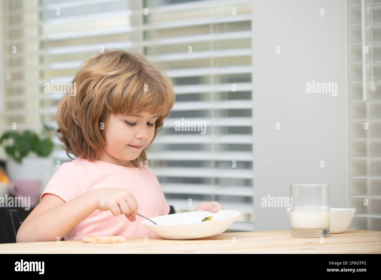 Child eating healthy food at home. Baby eat soup. Stock Photo