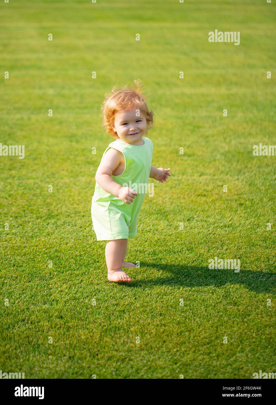 Happy baby in grass on the fieald at summer evening. Smiling child ...