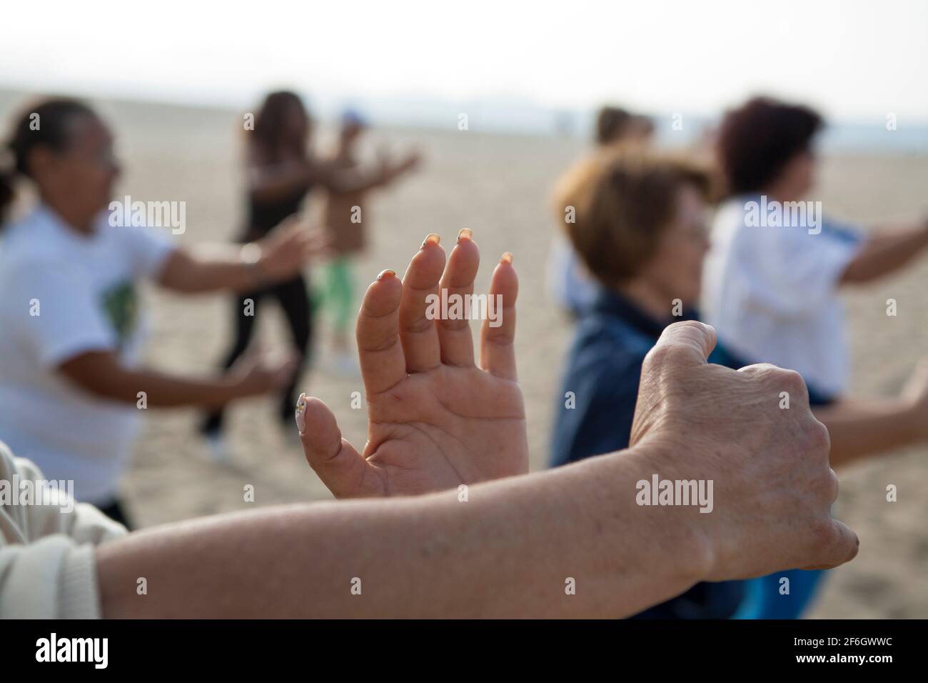 Group activity, Tai-chi-chuan class at Copacabana beach in the morning before work. Stock Photo