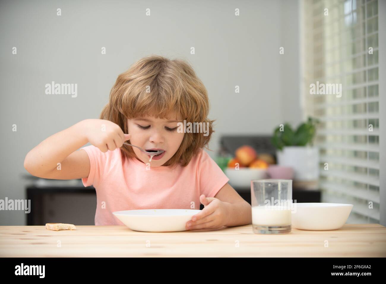 Little healthy hungry baby boy eating soup from with spoon. Child nutrition. Stock Photo