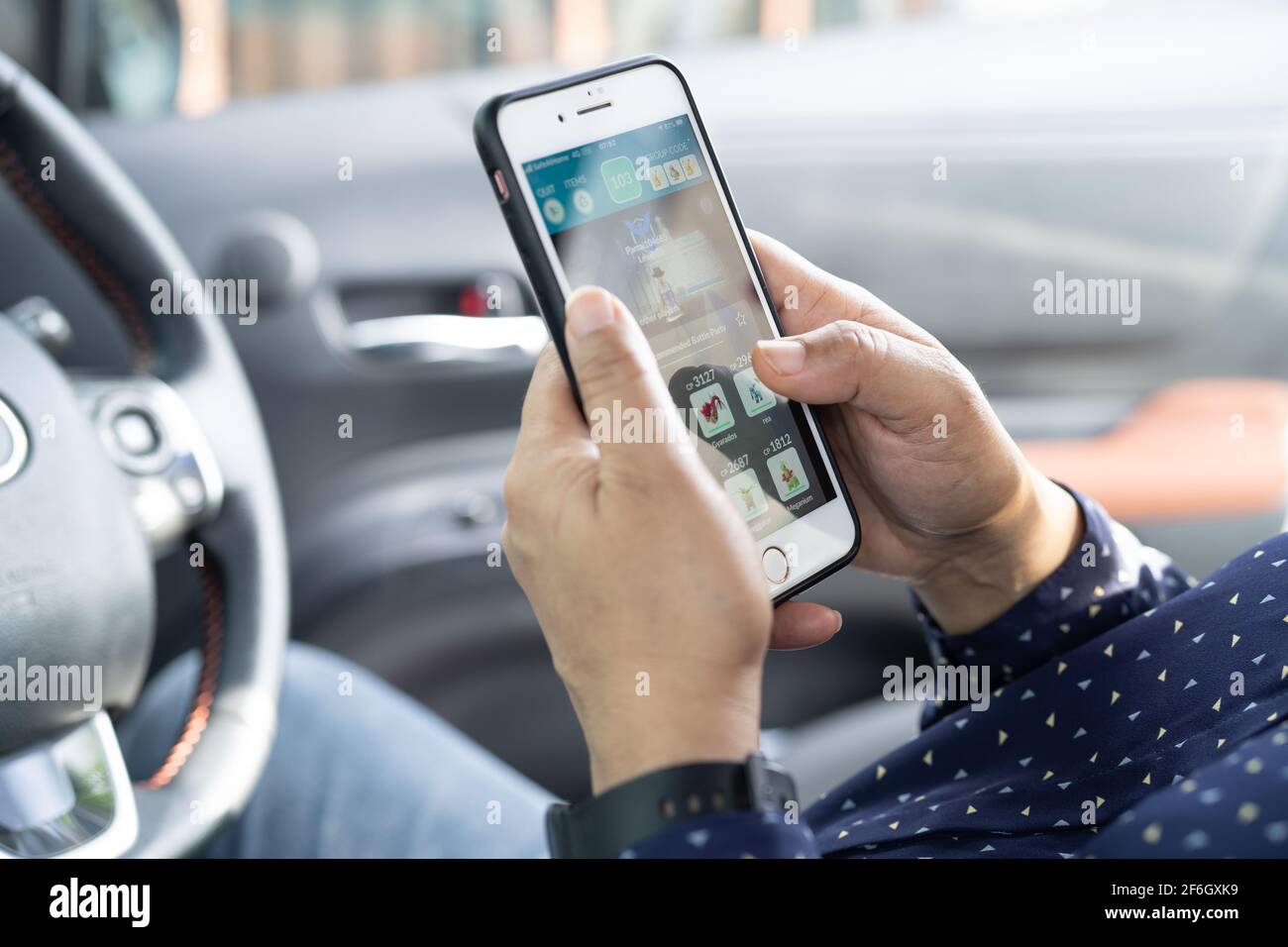 Bangkok, Thailand, July 1, 2020 Holding iPhone in toyota sienta car to communication with family and friends. Stock Photo