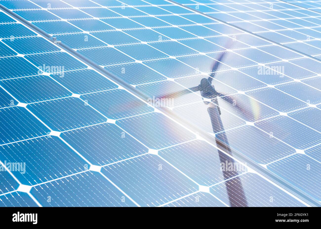 Wind turbine reflected in solar panels Stock Photo