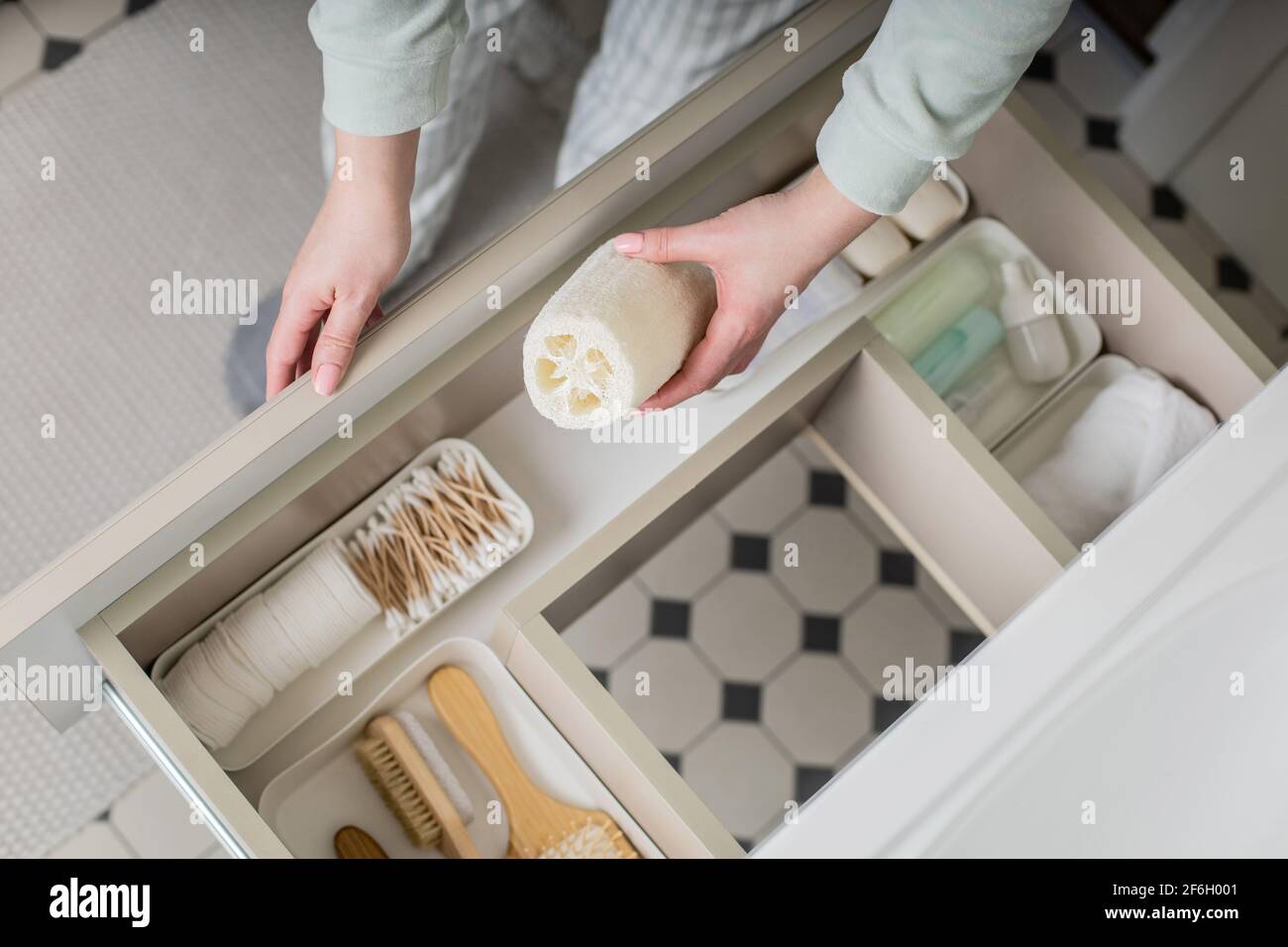 Top view female housewife organizing bathroom amenities and toiletries