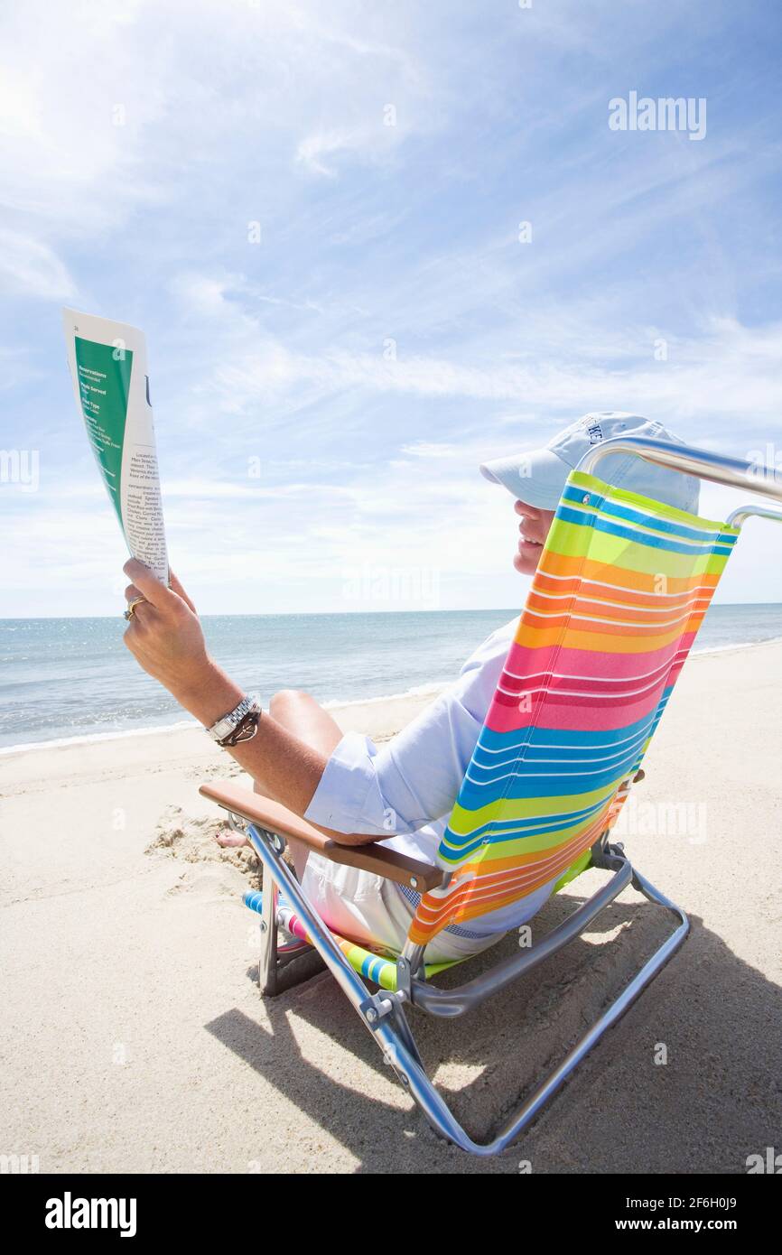 United States, Massachusetts, Nantucket, Woman reading magazine on beach Stock Photo