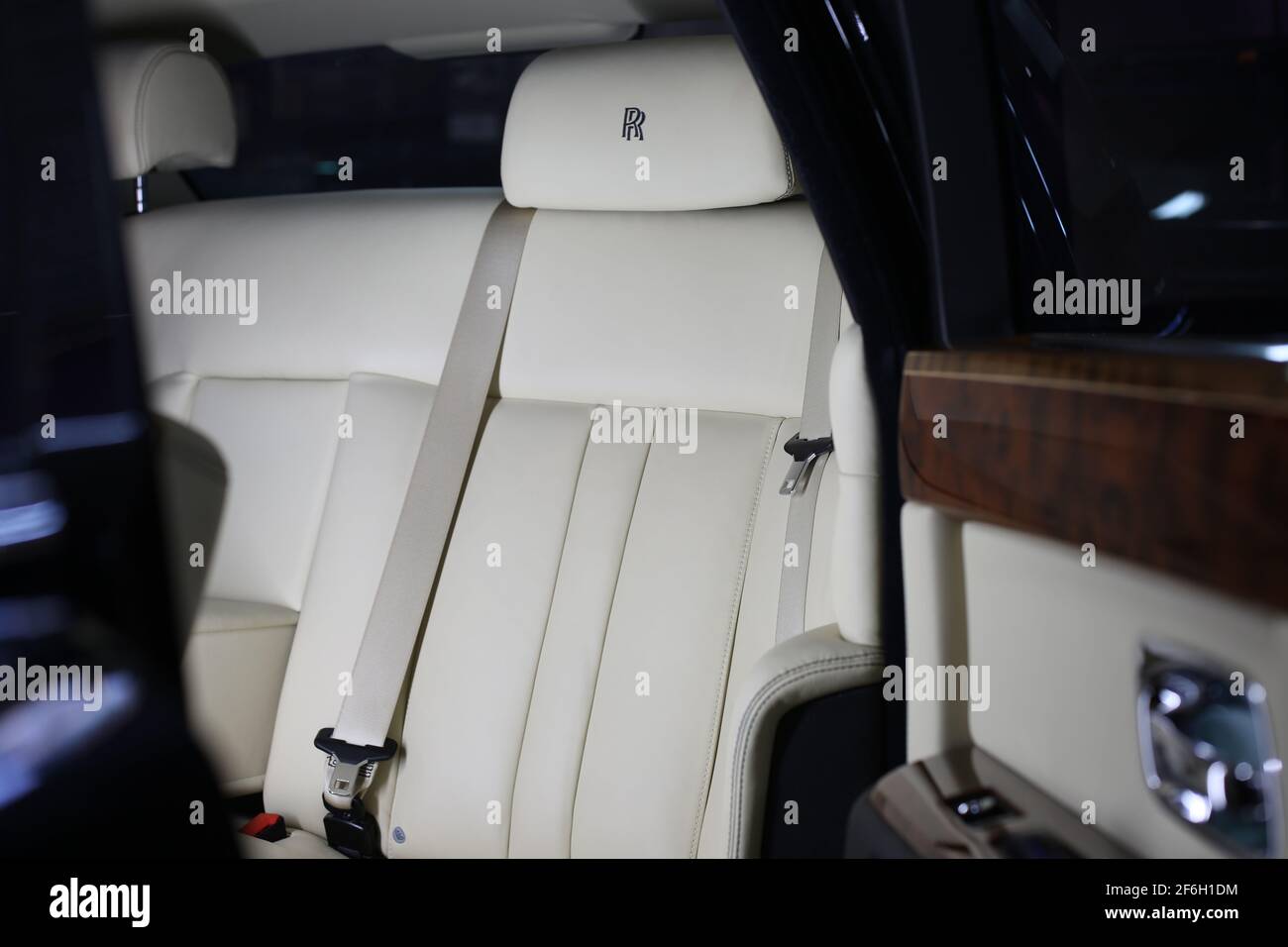 The Hand Stitched Headrest And Interior Of A 2009 Rolls Royce Phantom With White Leather And Wooden Door Trim Stock Photo