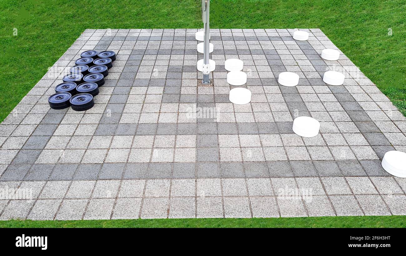 Game field outside mill lady black white lawn pattern lines chess board area play figures community lonely sport diamonds stones Stock Photo