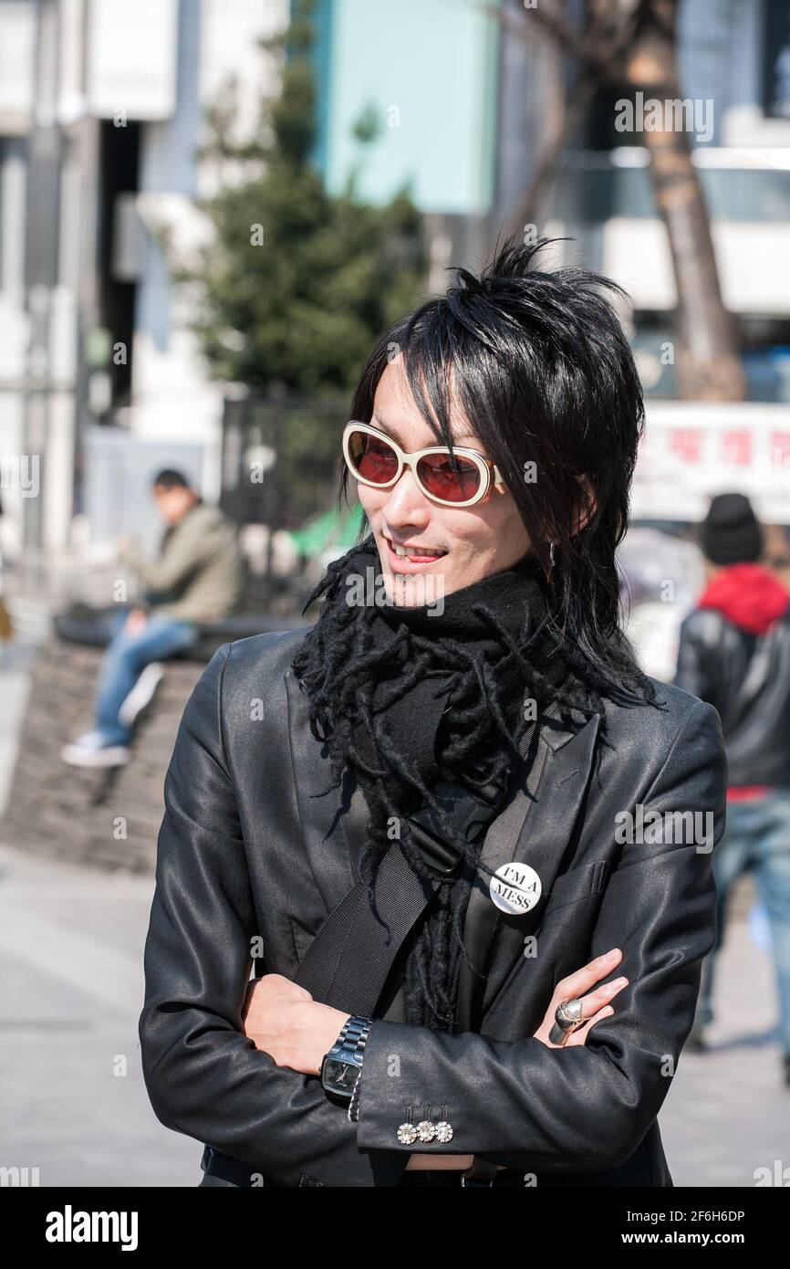 Close up of Japanese male host dressed like a rockstar wearing sunglasses hanging outside Shinjuku JR train station, Tokyo, Japan Stock Photo