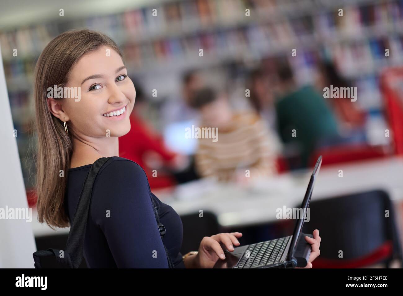 Female student working on laptop in college library Stock Photo - Alamy