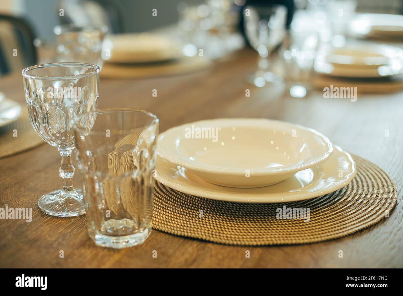 Wooden table with empty plates and glasses. Dinner table setting Stock Photo