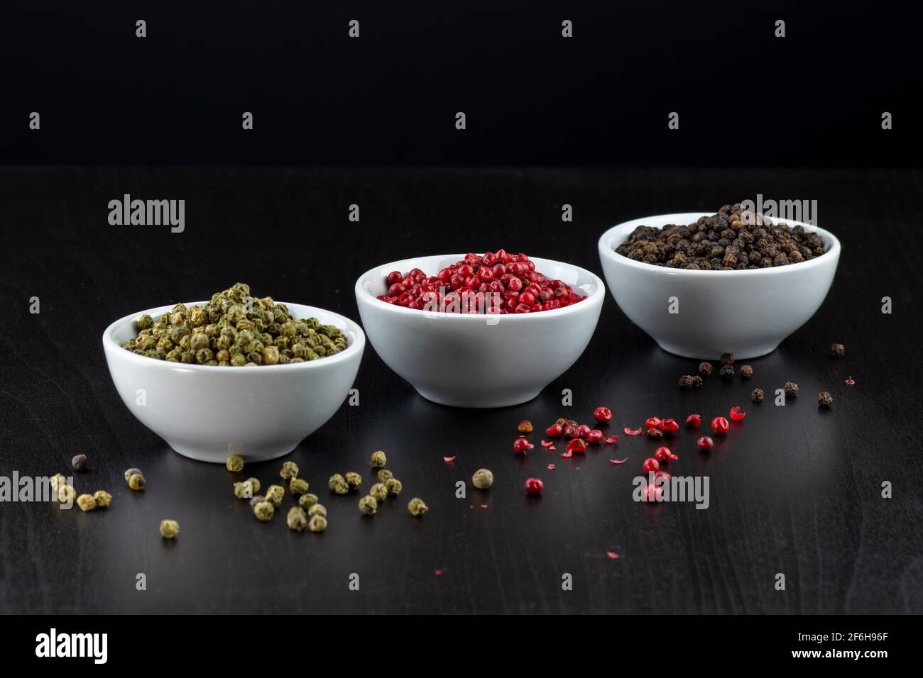 Peppercorns ,green, pink and black peppercorns on a black background Stock Photo