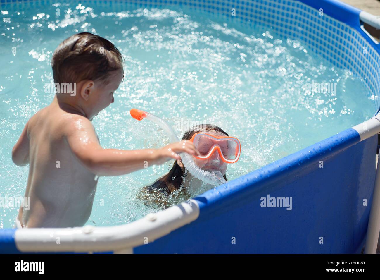 Children bath in the home swimming pool. Health benefits of hardening,  playing in water. Country holiday season Stock Photo - Alamy