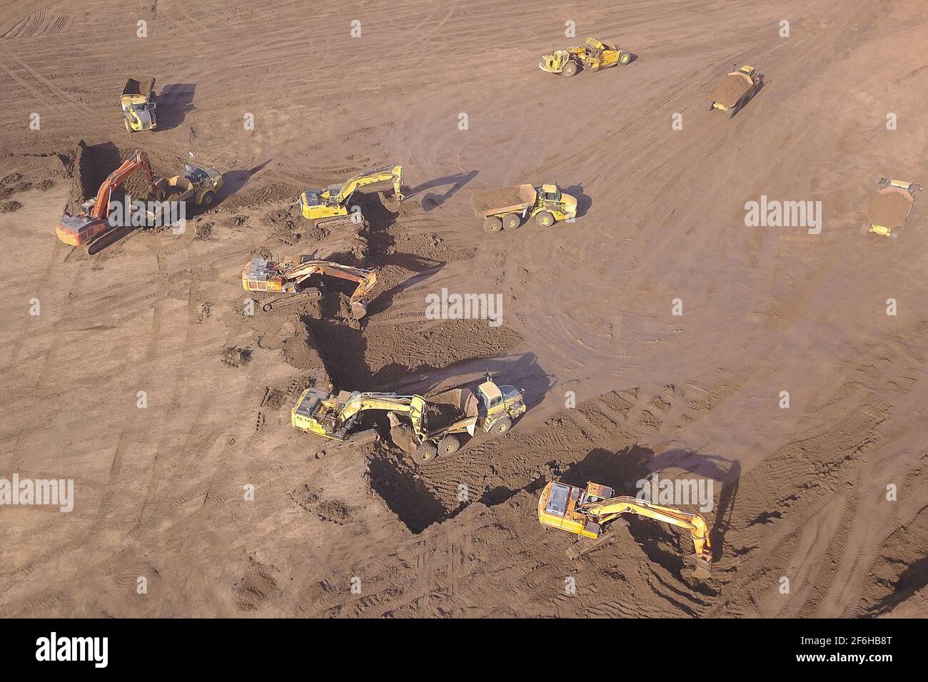 Several Earth moving equipment at new development site. Earth moving machines. Drone view on a New construction site.  Stock Photo