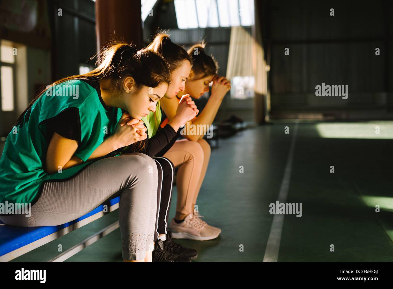 Players praying for success waiting final goal. Sportswomen prays with