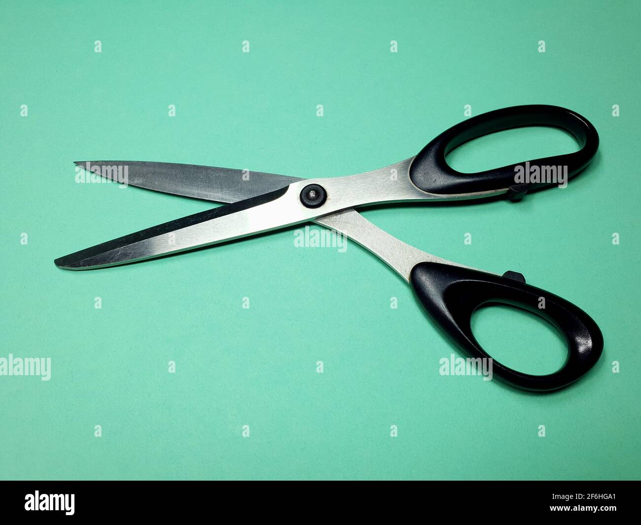 tailor scissors for cutting fabric on a green background Stock Photo