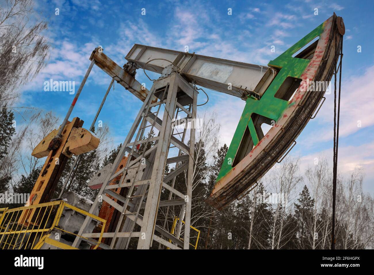 Oil pumpjack winter work is the overground drive for a reciprocating piston pump in an oil well. It is used to mechanically lift liquid out of the wel Stock Photo