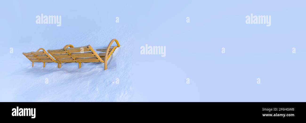 Vintage wooden Bench Painted yellow, rungs snow covered and in deep snow. Copyspace for Street Billboard placards texture background. Stock Photo