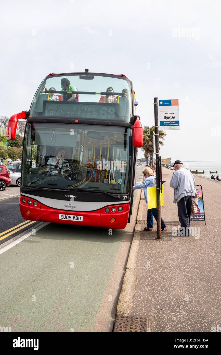 Senior couple boarding a bus in Southend on Sea, Essex, UK. Ensignbus open top Seaside Special bus route. Bus stop on seafront Stock Photo