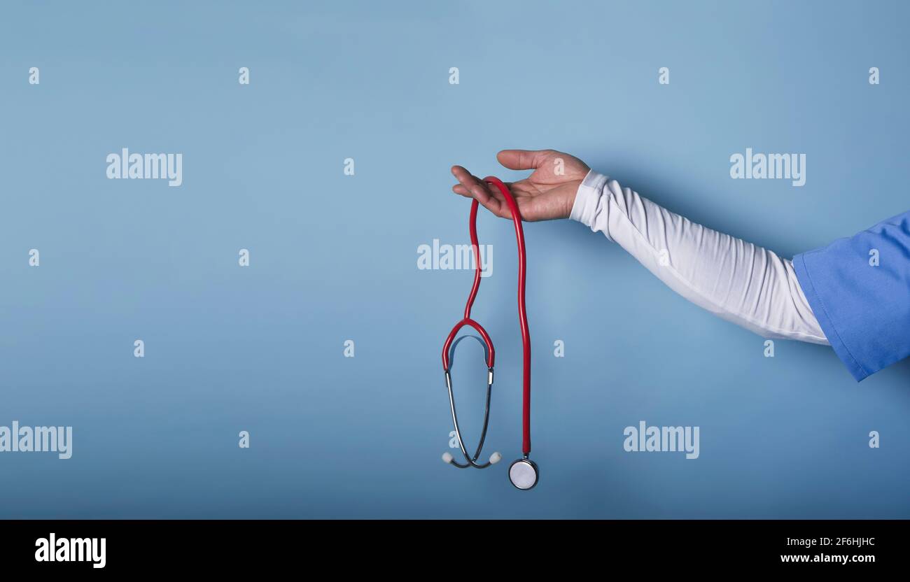 Doctor hand with stethoscope isolated on a blue background Stock Photo