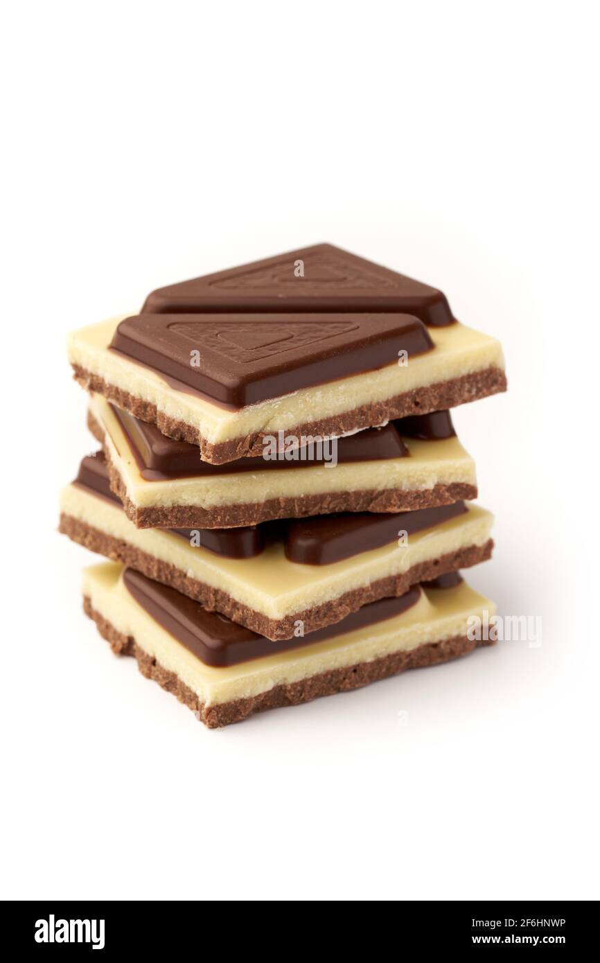 Close up of stack of pieces of milk chocolate isolated on white ...