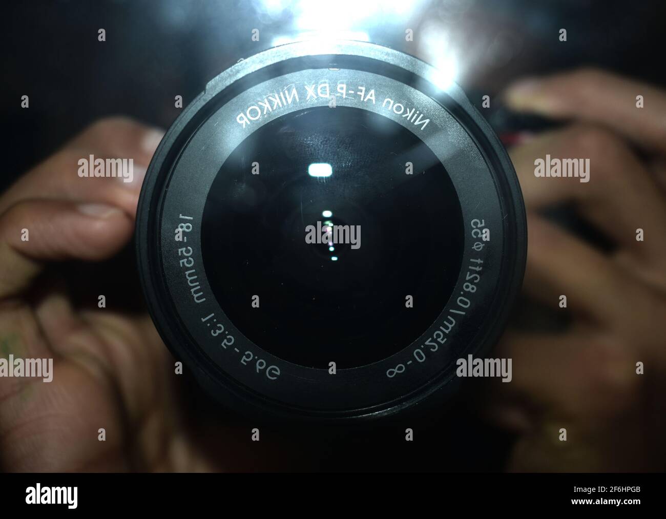 photo of a Nikon DSLR lens with the flash on creating glare. Stock Photo