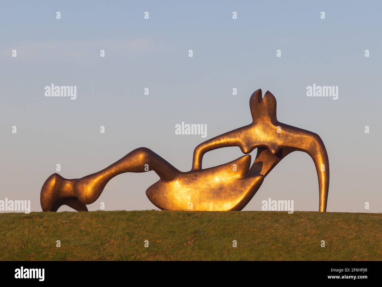 Henry Moore's Large Reclining Figure sculpture in the early morning sunlight.  Perry Green, Hertfordshire. UK. March 2021 Stock Photo