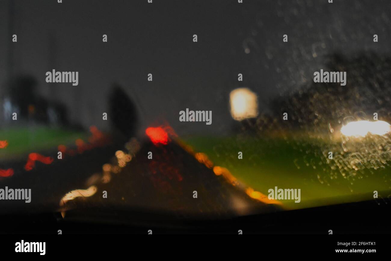 slightly blurred photo of reflectors on the road during a rainy night with raindrops visible on the glass. Taken during floods in Sydney March 2021 Stock Photo