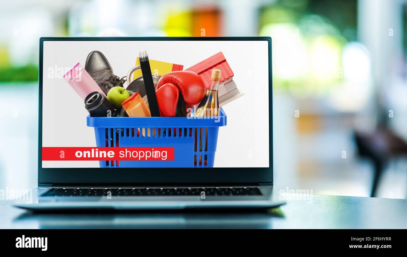 Laptop computer displaying a shopping basket with consumer goods. Online shopping. E-commerce Stock Photo