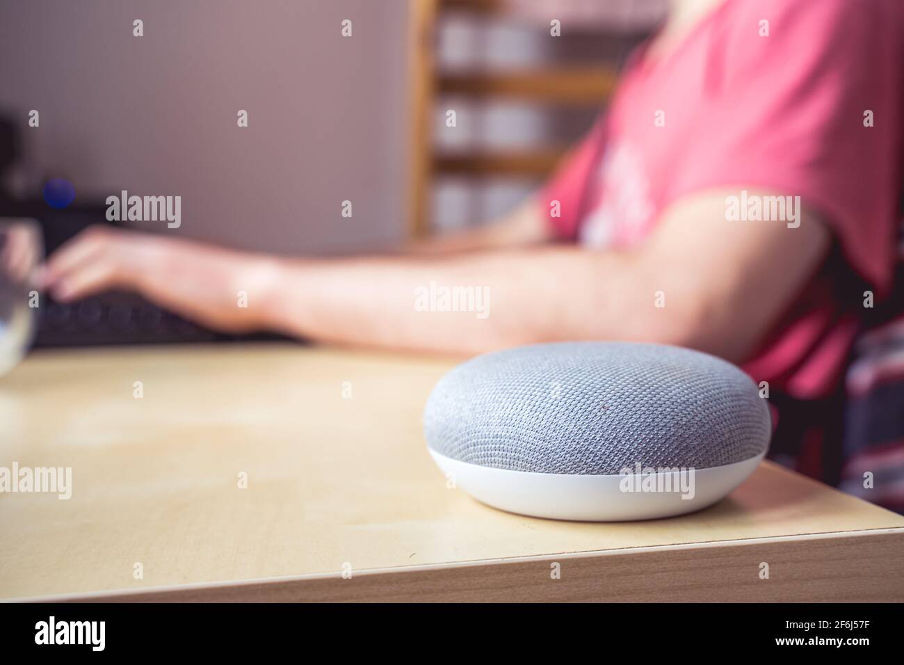 voice controlled smart speaker in a interior. male working in background Stock Photo