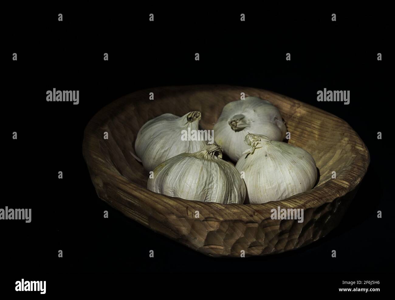 Garlic in wooden bowl Stock Photo - Alamy