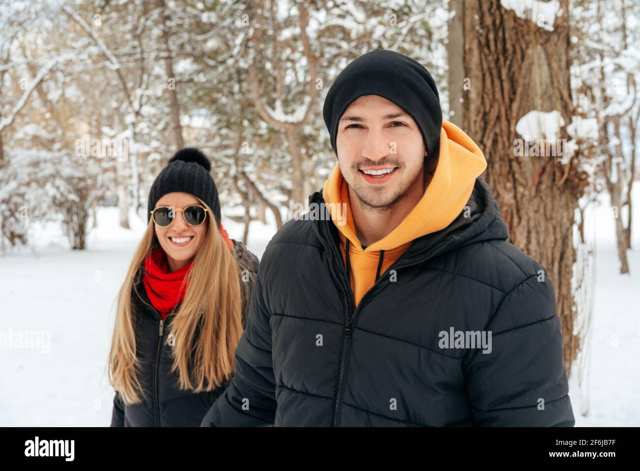 Happy couple hugging and smiling outdoors in snowy park Stock Photo - Alamy