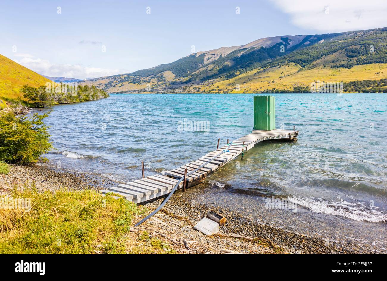 Green lakeside outdoor toilet shed standing at the end of a wooden jetty on Languna Azul, Torres del Paine National Park, Patagonia, southern Chile Stock Photo