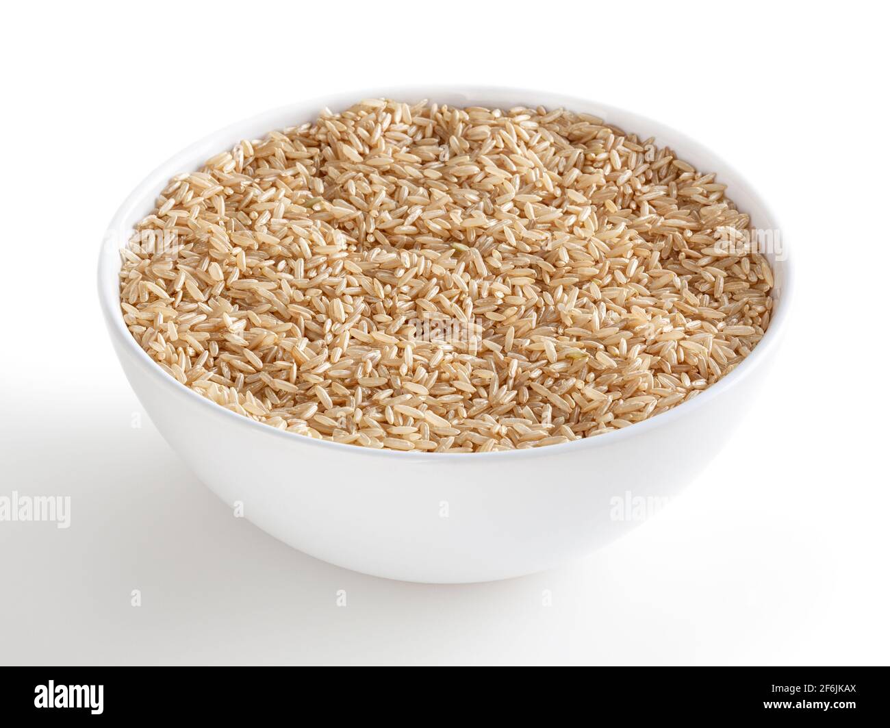 Brown rice in white bowl isolated on white background with clipping path Stock Photo