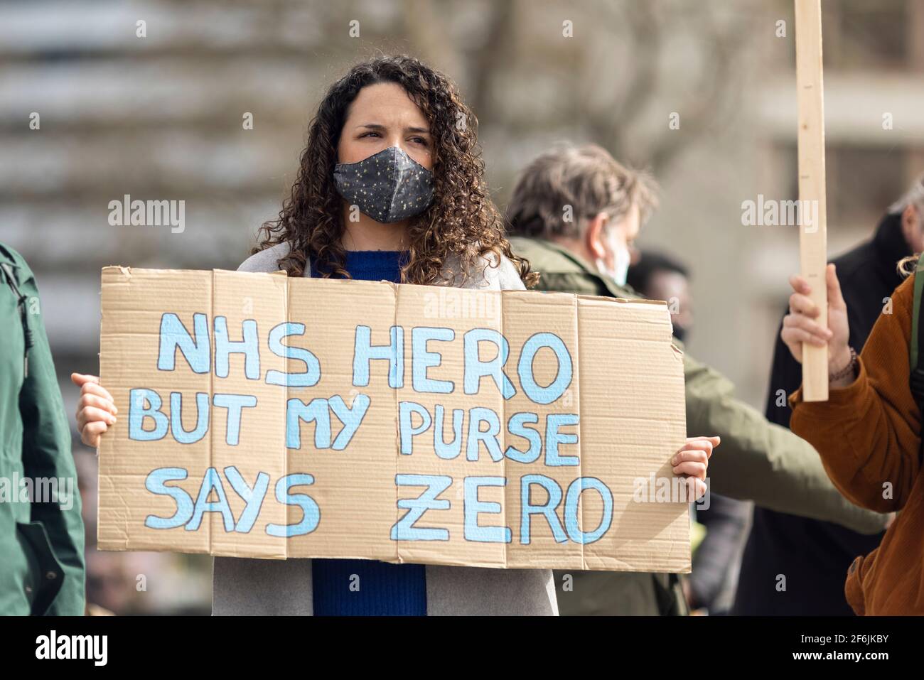 London, UK. 1st Apr, 2021. A protester holding a placard reading 'NHS Hero But My Purse Says Zero'. NHS workers protested over the proposed 1% pay rise from the government outside St Thomas’ Hospital, Westminster Bridge Road, London, UK. Credit: Joshua Windsor/Alamy Live News Stock Photo