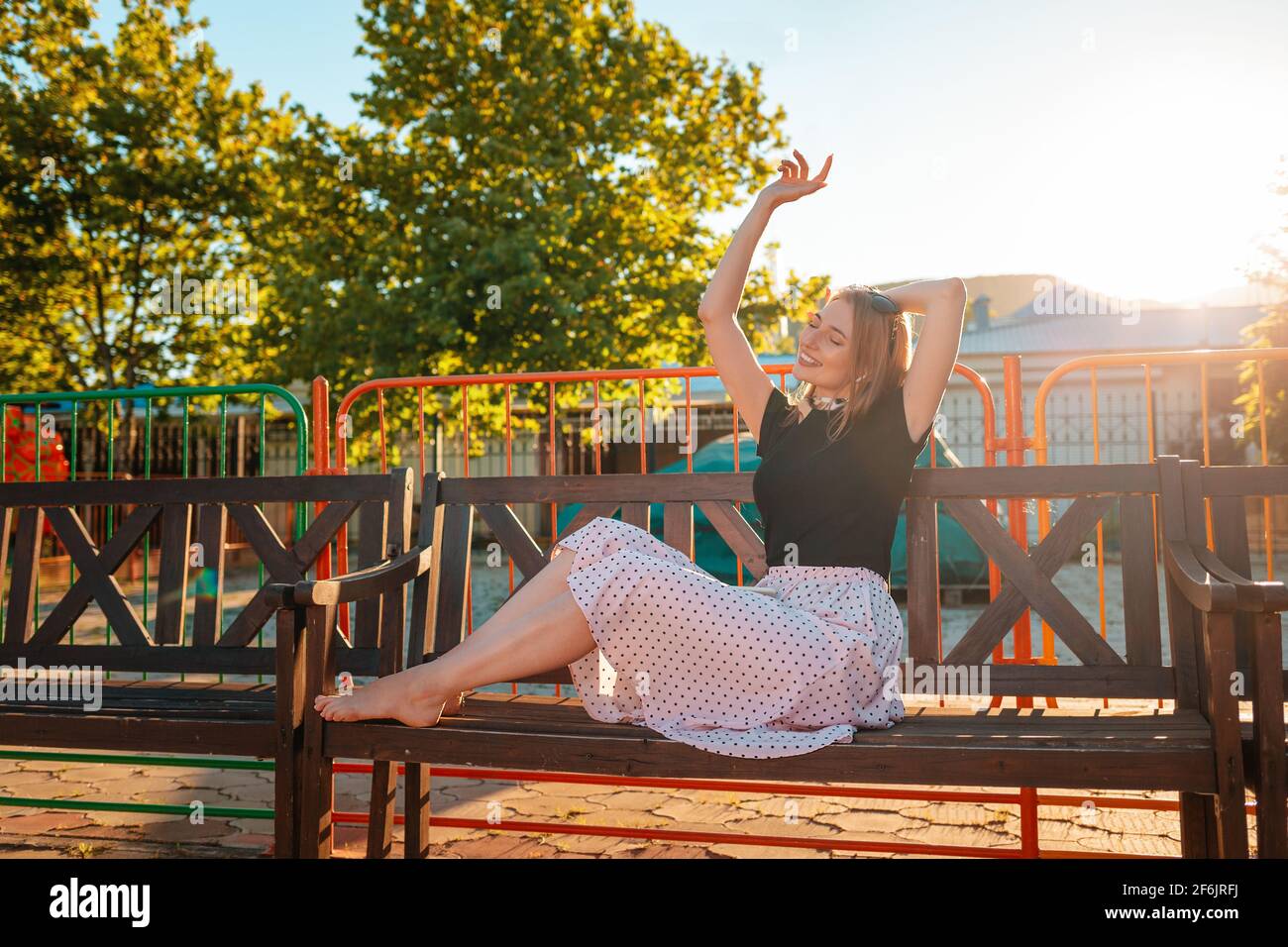Summer vacation. A beautiful young woman is sitting on a Park bench ...