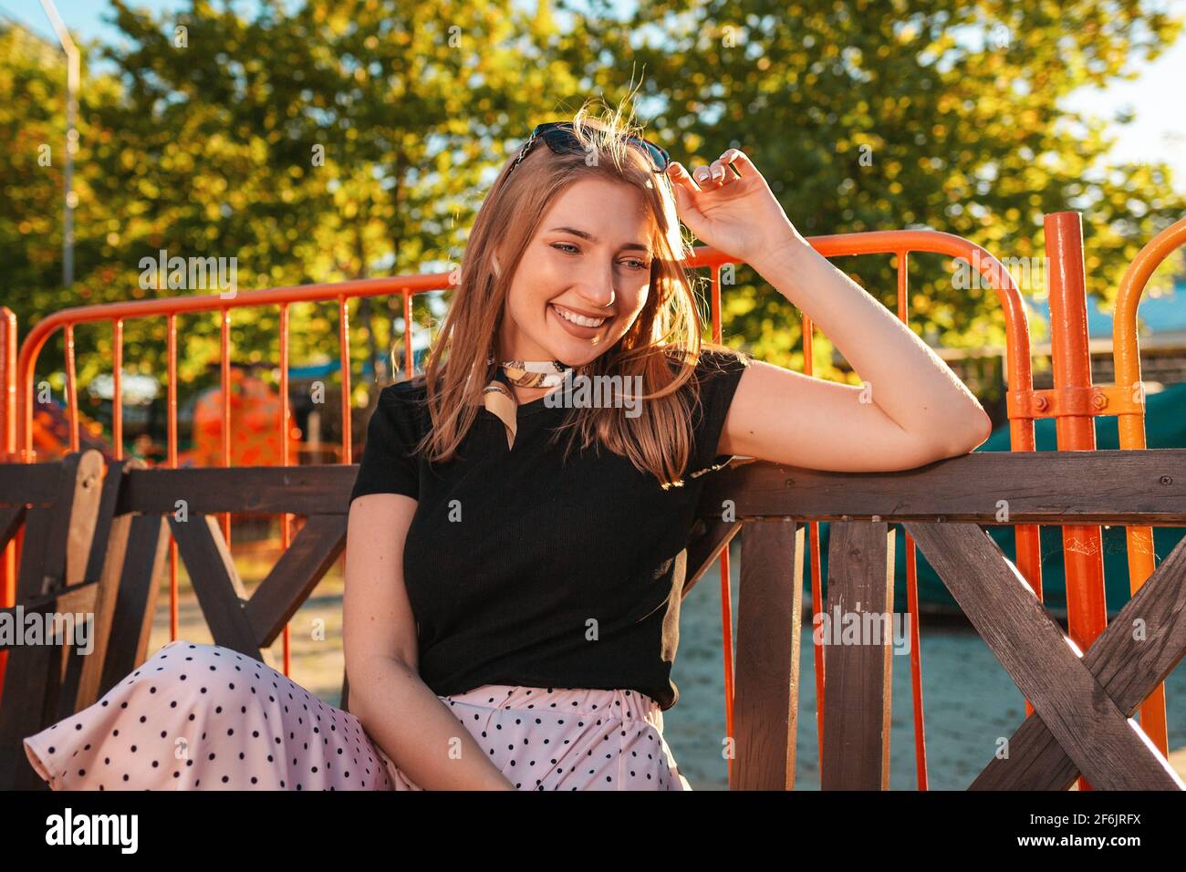 Summer vacation. Portrait of a beautiful young woman is sitting on a ...