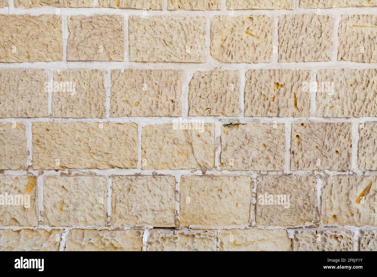 Old wall made of yellow sandstone bricks, closeup background photo texture Stock Photo