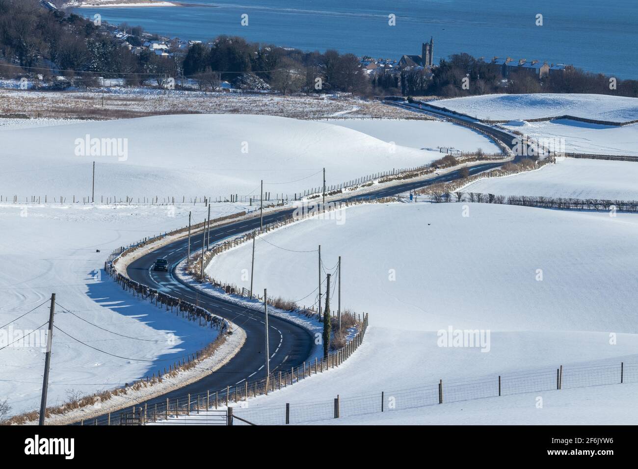 Snowy fields and a rural road leading to Burntisland, Fife, Scotland Stock Photo