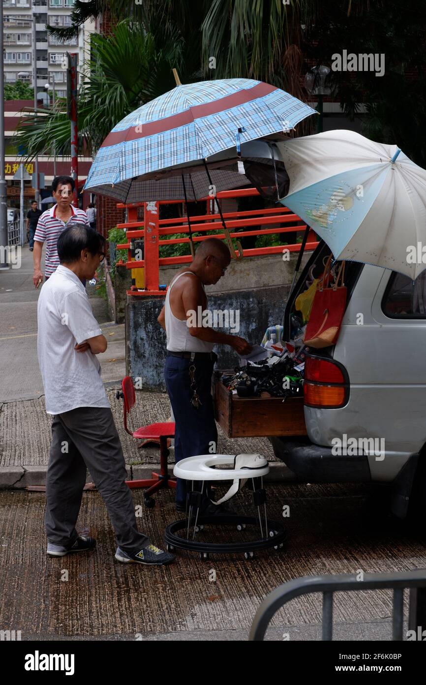 A pair of old men selling used electronic goods from the back of a van in Garden Rivera Shatin Hong Kong Stock Photo
