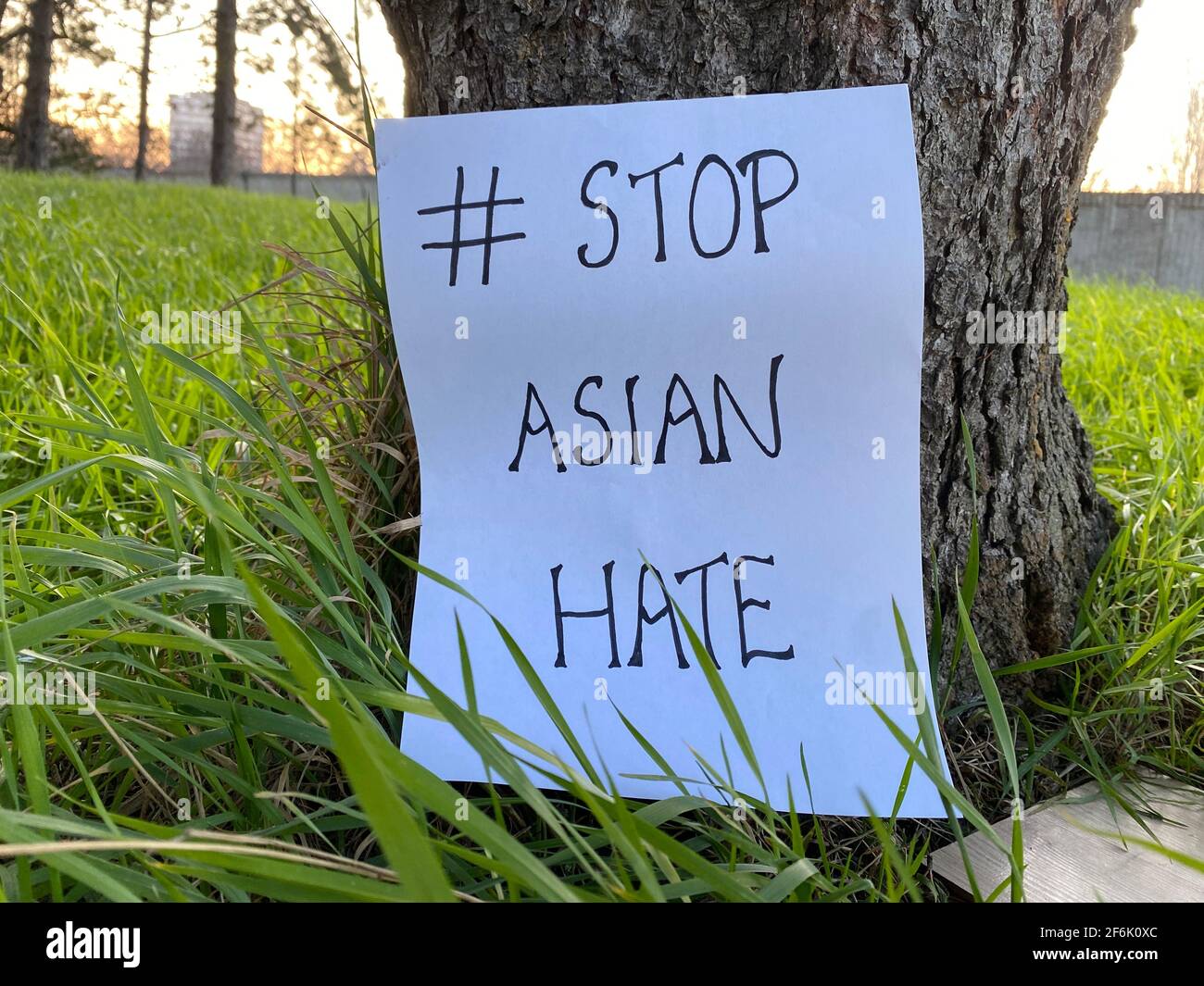 Stop Asian Hate, says the sign at the bottom of a tree. Show solidarity to all Asians suffering from racism. Asian Lives Matter movement protest. Stock Photo