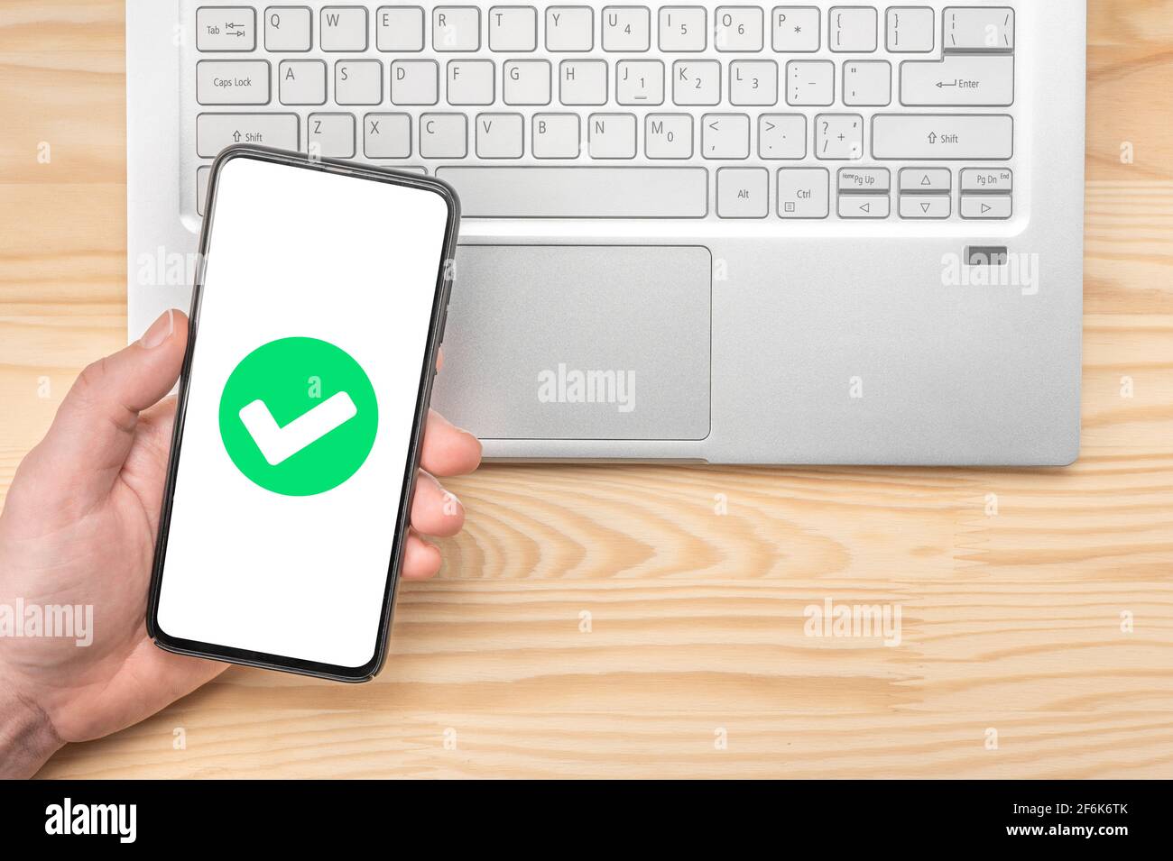 cell phone confirmation. Smartphone with green checkmark on screen, validated, confirmed, completed, approved. Confirmed Smartphone Order Success. han Stock Photo
