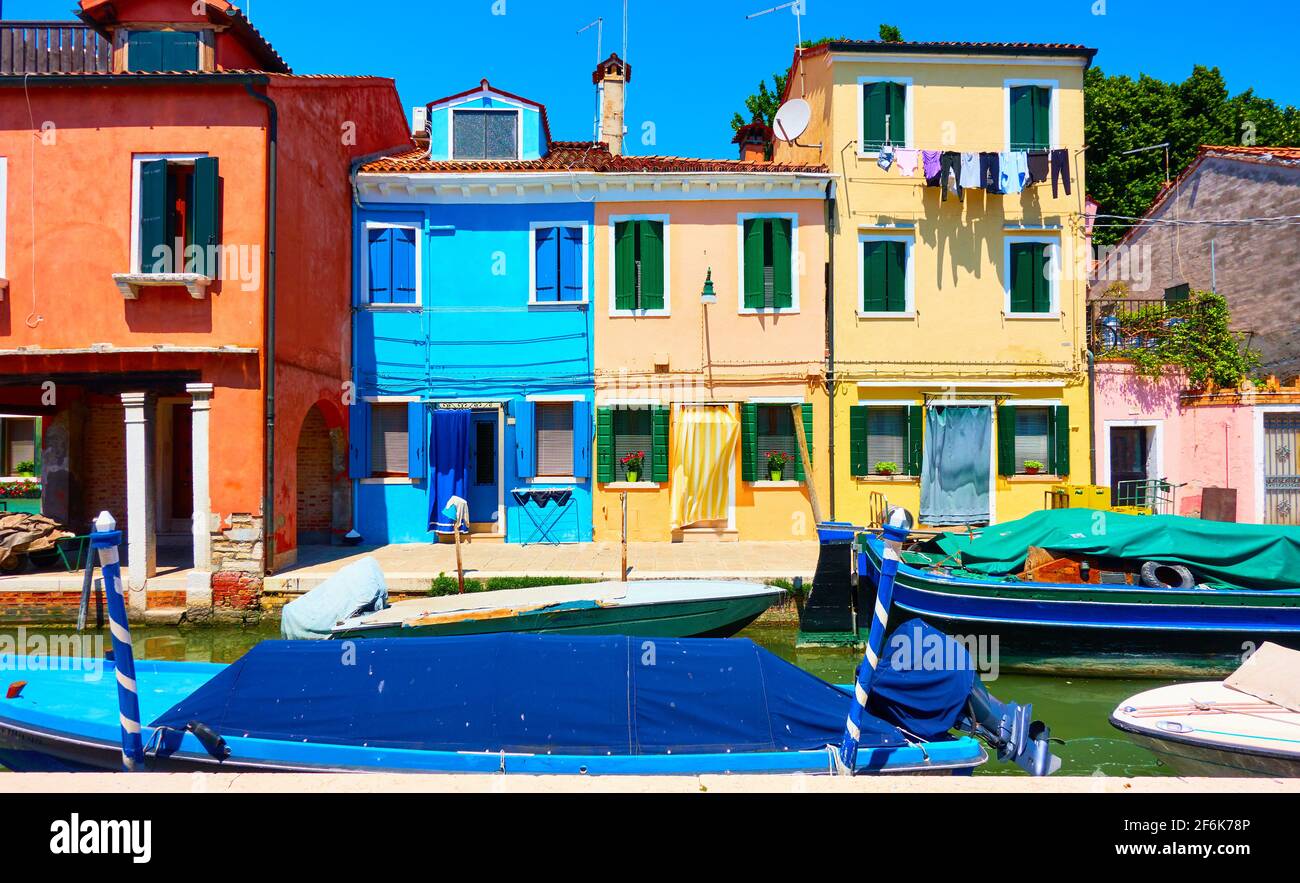 Cozy colorful houses and canal with boats in Burano Island in Venice, Italy. Cityscape, venetian view Stock Photo