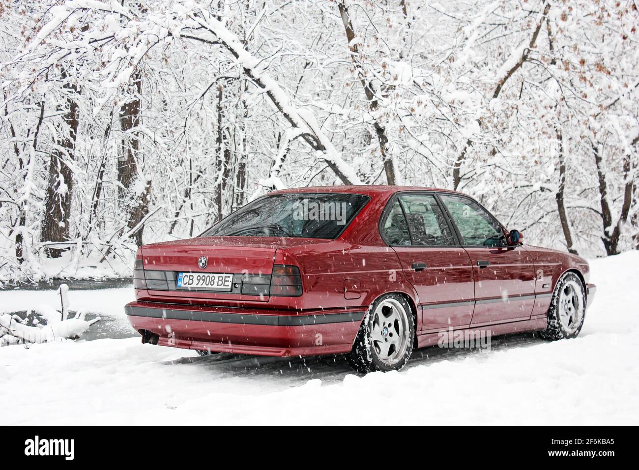Chernigov, Ukraine - December 21, 2017: BMW 520 (E34) in the winter forest. Red BMW in a beautiful forest. Nature. Snow Stock Photo