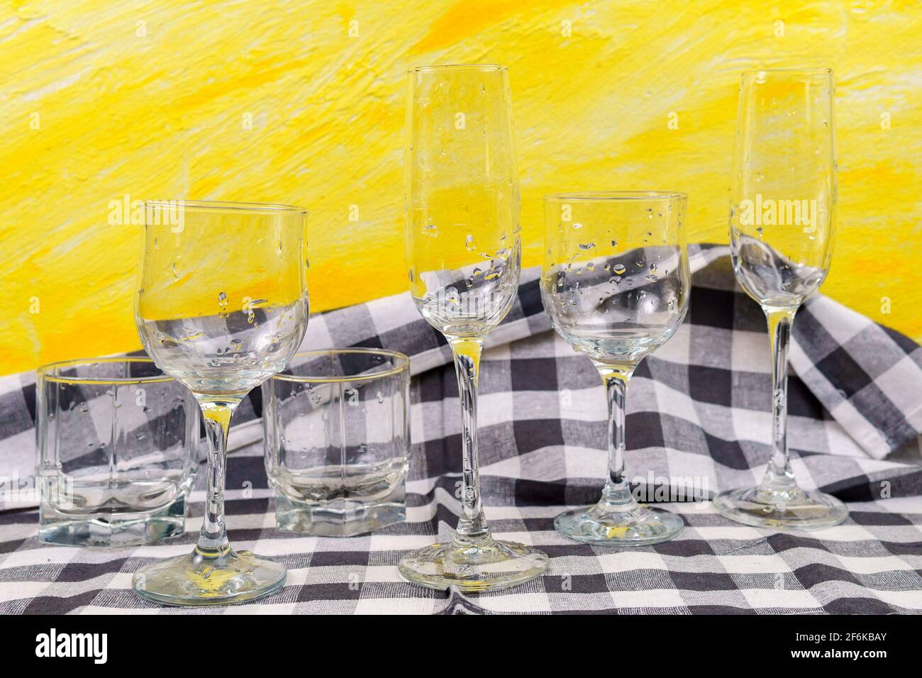 Set of glasses for different alcoholic drinks on yellow background